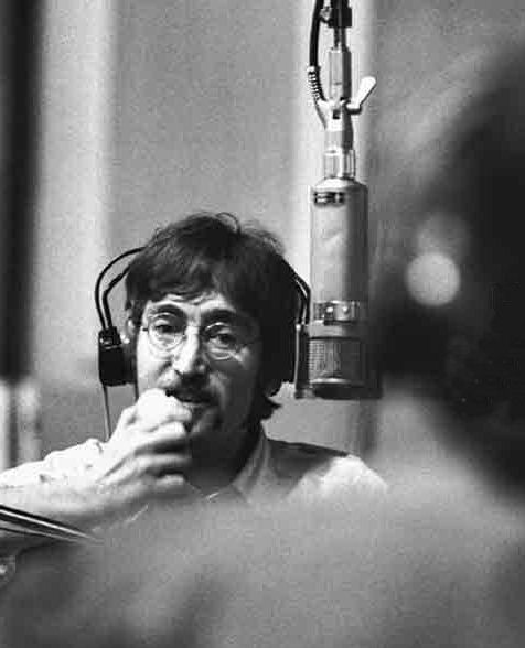 John Lennon davanti ad uno dei suoi "strumenti" principali: il più bel microfono della storia, il Neumann U47